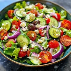 a salad with cucumbers, tomatoes, onions and feta cheese in a bowl