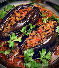 stuffed eggplant in tomato sauce and garnished with cilantro leaves