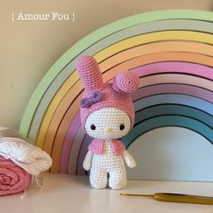 a crocheted hello kitty doll next to a rainbow