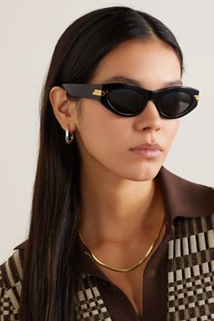 Bottega Veneta's sunglasses have classic cat-eye frames reminiscent of styles from the '60s. They're made from glossy black acetate with gray tinted lenses and polished gold-tone bars at the temples. Store yours in the case when you're not wearing them. Cat Eye Black Sunglasses, Sunglasses Women Oversized Classy, Sunglasses Women Popular, Popular Sunglasses Nordstrom, Black Sunglasses Women Cat Eye, Cat Eye Sunglasses On Round Face, Black Straight Sunglasses, Cazal Sunglasses Women, Big Trendy Sunglasses