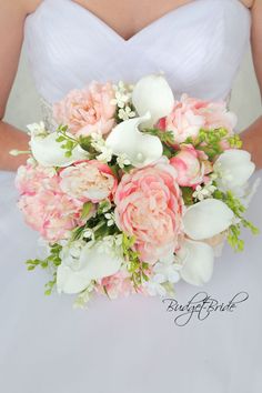 a bride holding a bouquet of pink and white flowers