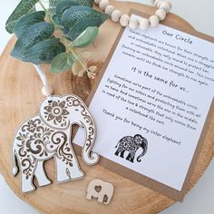 an elephant and its baby are next to a note on a wooden board with a plant