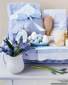 a basket filled with blue and white items on top of a table next to a vase