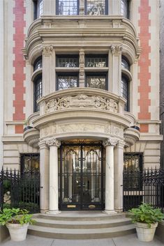 the front entrance to an apartment building with wrought iron gates and pillars on either side