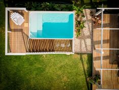 an overhead view of a small pool and deck in the grass with chairs around it