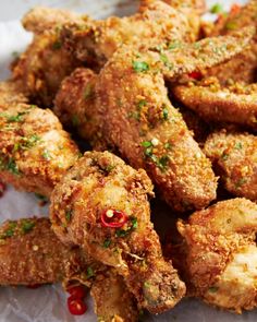 some fried food on a white plate with red peppers and parsley sprinkles