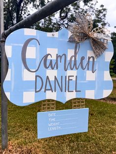 a blue and white sign that says garden danielle on it's side in front of some grass