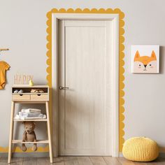 a baby's room with an orange and yellow wall decal on the door