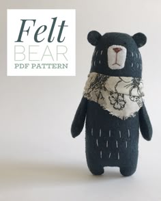 a stuffed bear with a scarf around it's neck and the words felt bear