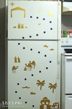 the refrigerator is decorated with gold and white christmas wall decals on it's side