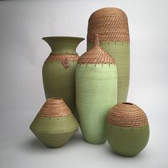 several green vases are stacked on top of each other in front of a white background