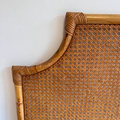 a wicker headboard with an intricate design on the top and bottom part, against a white wall