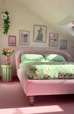 a bedroom with pink walls and green bedding in the corner, along with pictures on the wall