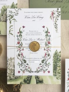 the wedding stationery is laid out on top of each other, including a gold coin