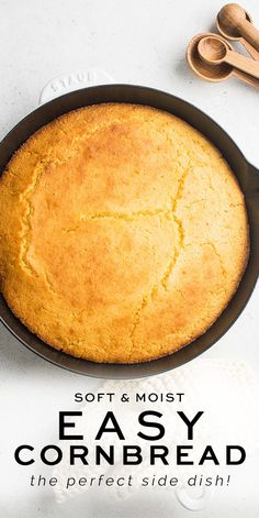 an easy cornbread in a cast iron skillet on a white table with spoons