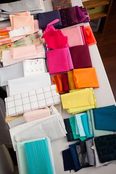 many different colored pieces of fabric on a table