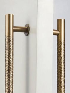 two gold colored handles on the side of a white door