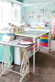 a sewing room with lots of crafting supplies on the table and colorful wallpaper