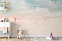 a child's room with pink and blue clouds painted on the wall