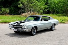 an old muscle car parked in a parking lot