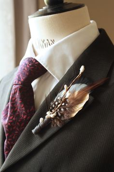 a man wearing a suit and tie with feathers on it