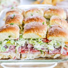 a large sandwich cut in half sitting on top of a pan filled with meat and lettuce