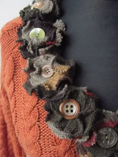 an orange sweater with buttons attached to it