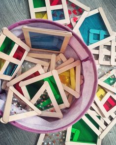 a bowl filled with lots of colorful wooden blocks