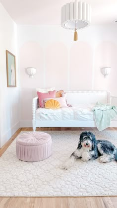 a dog laying on top of a rug next to a bed in a room with white walls