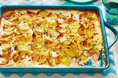 a casserole dish with potatoes and herbs in it sitting on a blue plate