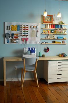 a craft room with blue walls and wooden floors