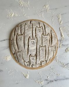 a ceramic plate with cats on it sitting on a counter top next to a wall