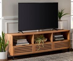 a flat screen tv sitting on top of a wooden entertainment center in a living room