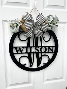 a monogrammed door hanger with a bow on it's front door