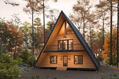 a - frame cabin in the woods surrounded by trees