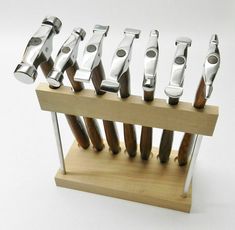 there are many different types of knifes on the wooden stand with each one in it's own holder