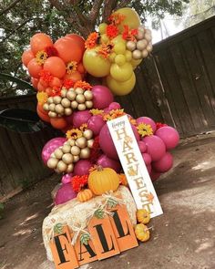 balloons and decorations are arranged in the shape of a fall tree for an autumn themed birthday party