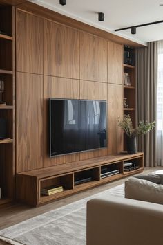 a living room with wooden shelves and a flat screen tv mounted on it's wall