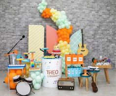 an assortment of musical instruments and balloons in front of a brick wall