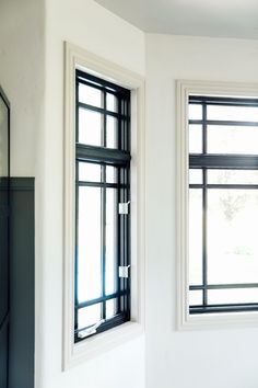 two windows in a white room with black trim