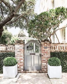 an instagramted photo of a front door with two planters on either side