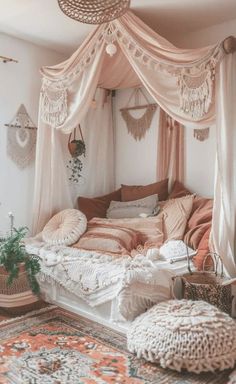 a canopy bed with lots of pillows and blankets