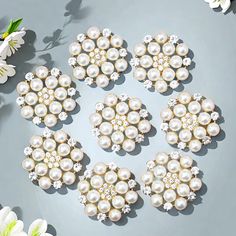 several white flowers and pearls on a blue surface