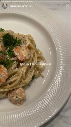 a white plate topped with pasta and shrimp