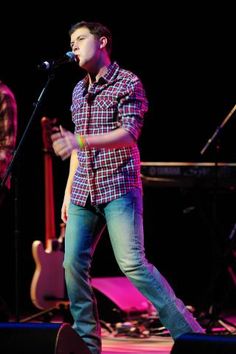 a man standing on top of a stage holding a microphone