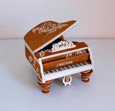 a miniature piano made out of cardboard with music notes on the keys and an ornate top