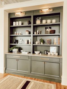 a living room filled with lots of furniture and shelves full of candles on top of them