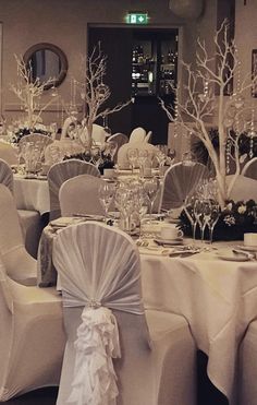 the tables are set with white linens and centerpieces for an elegant wedding