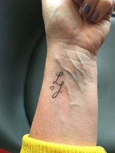 a woman's arm with a tattoo that says love on the left side of her wrist