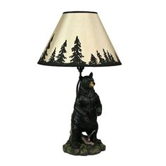 a bear lamp sitting on top of a table next to a white and black shade